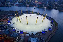 The O2 Stadium from a birds eye view lit up at night.