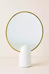 A small white Pandora Tabletop Mirror with a gold frame on a beige background